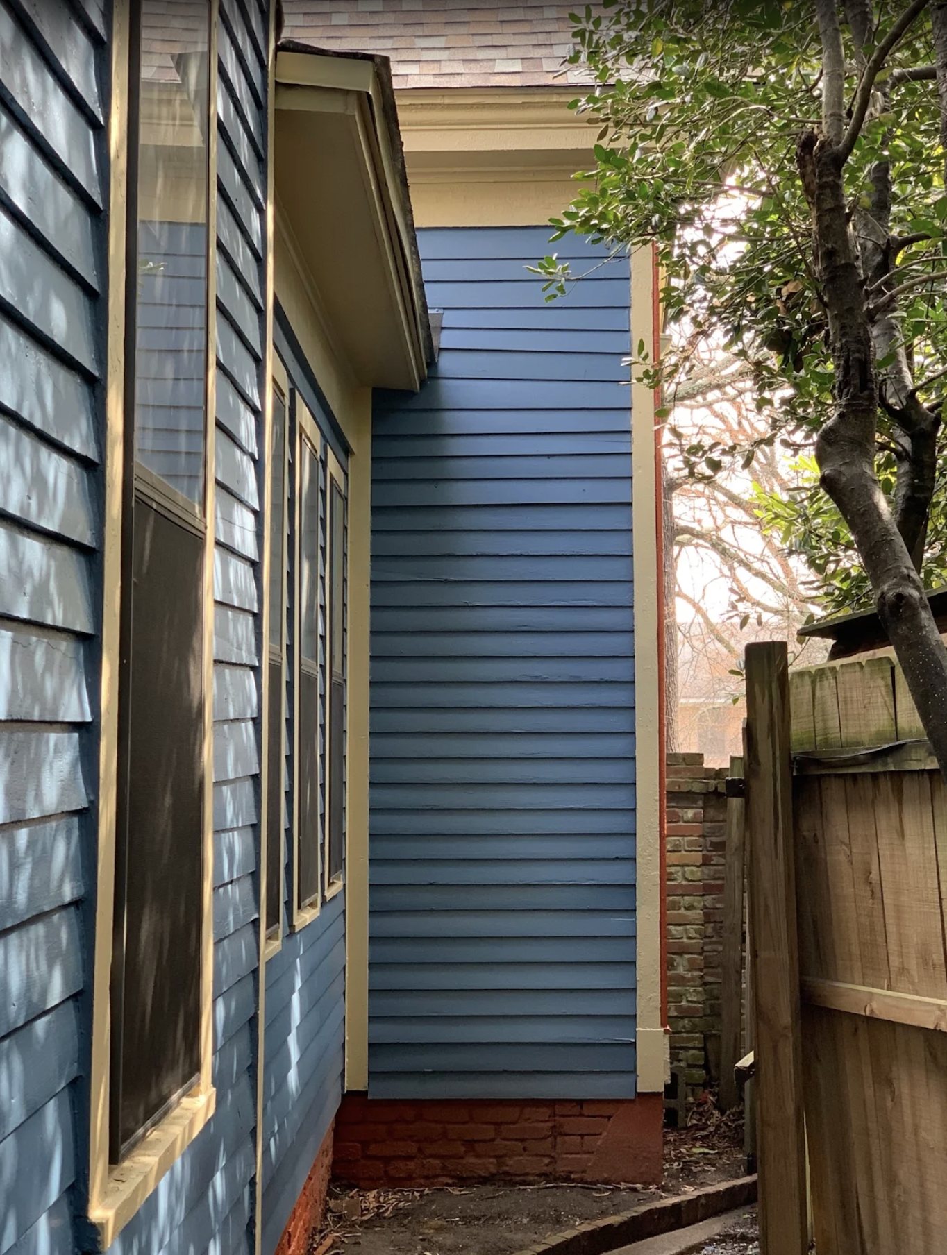 Blue lap siding and window trim being repainted on a Little Rock home