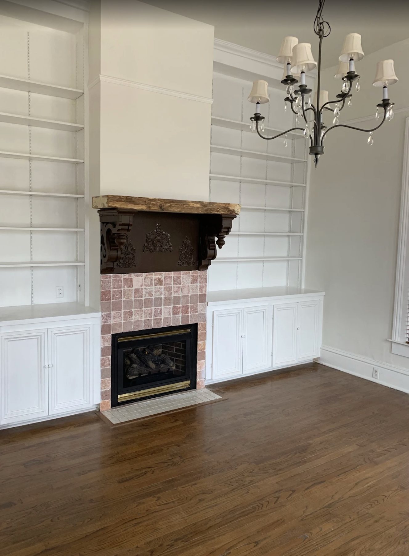 White painted built-in bookcases flanking a brick fireplace
