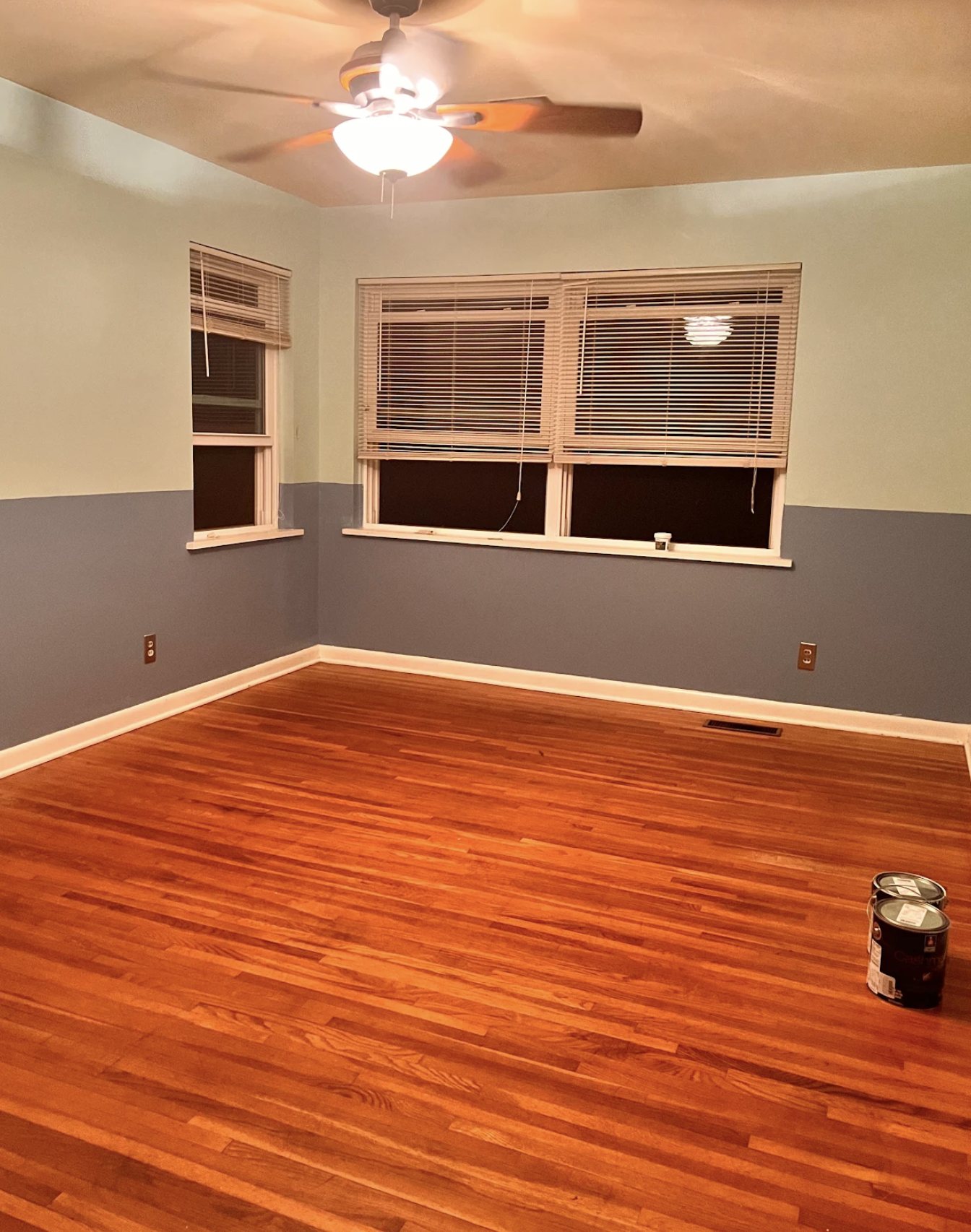 Room painted in two tones above and below the chair rail with refinished hardwood floor