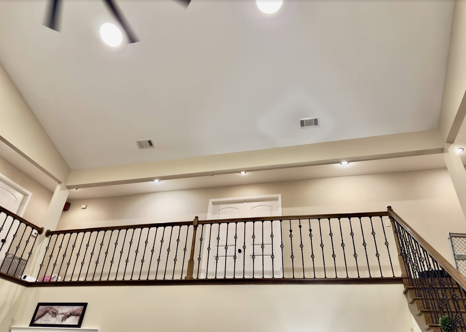 Upstairs landing and railing with freshly painted walls and tray ceiling